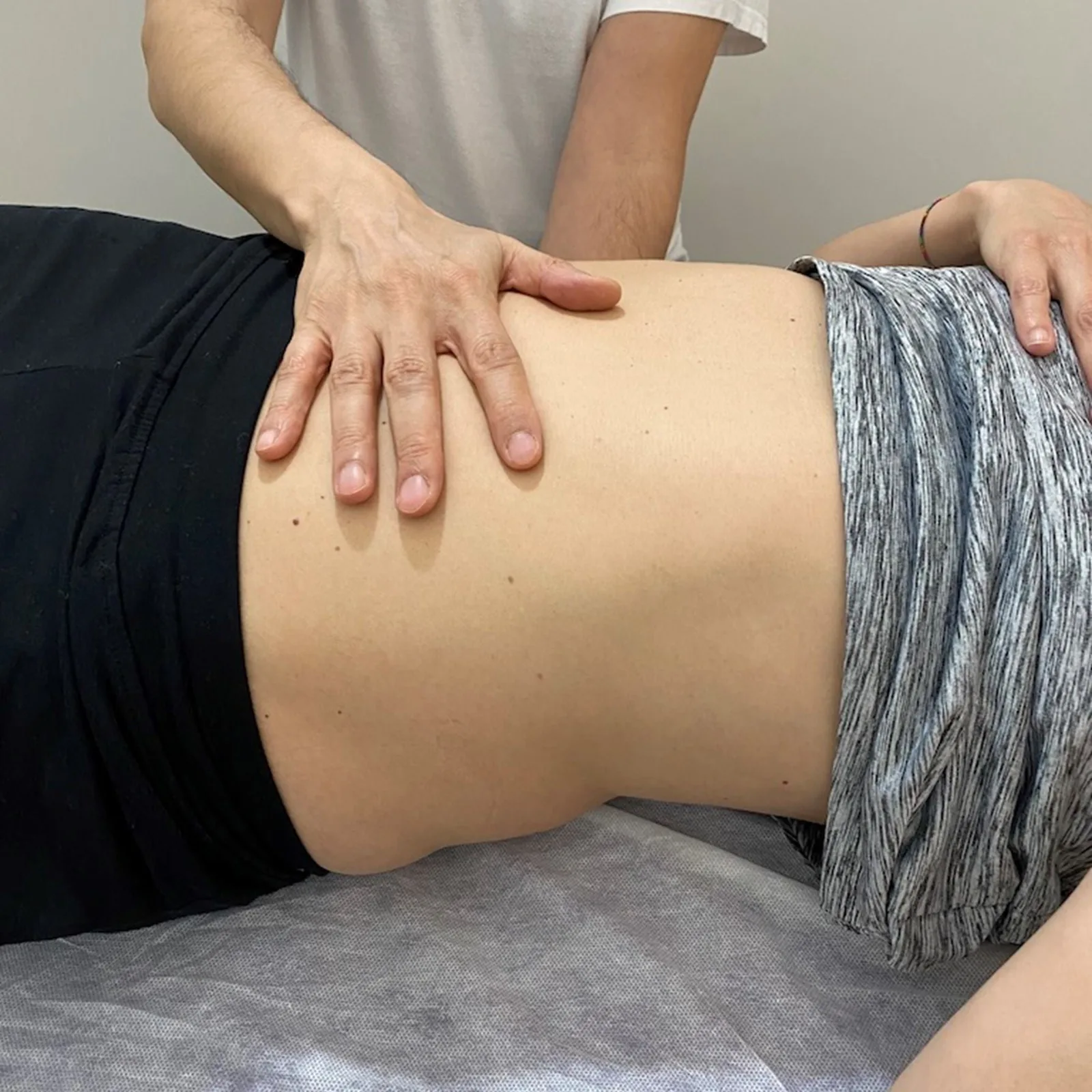 Manos del terapeuta trabajando sobre la zona lumbar