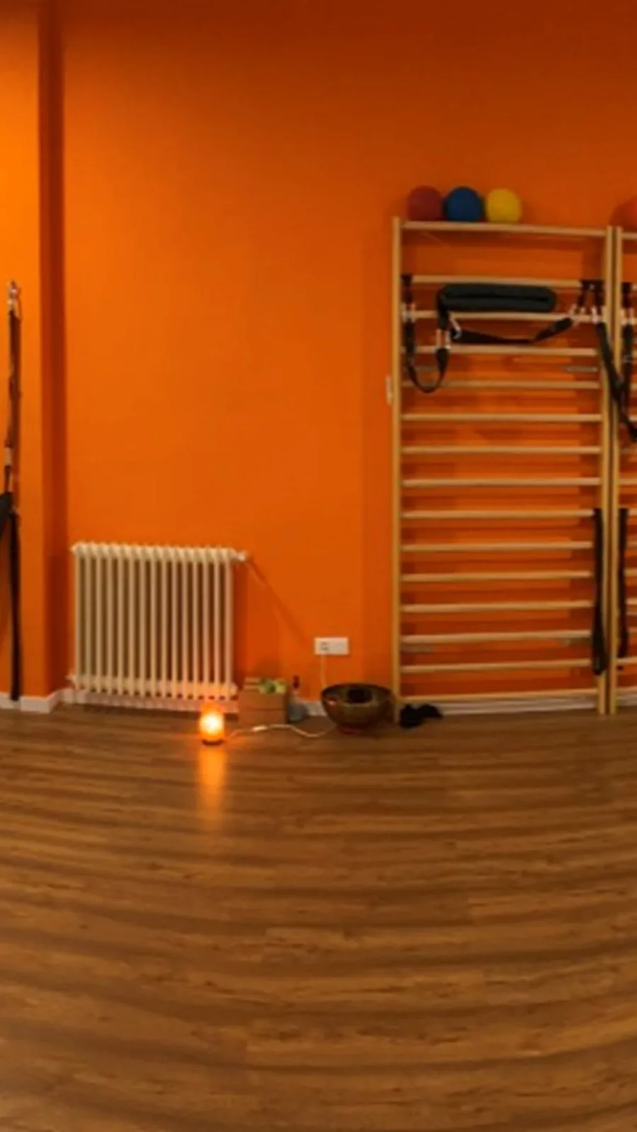 Rincón de la sala con las espalderas y una vela encendida